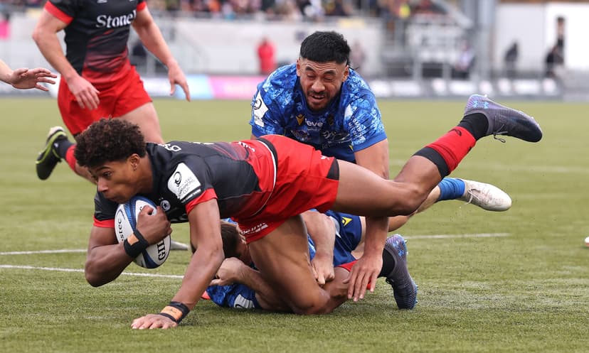 Noah Caluori of Saracens is held by Alex Newsome and Irae Simone